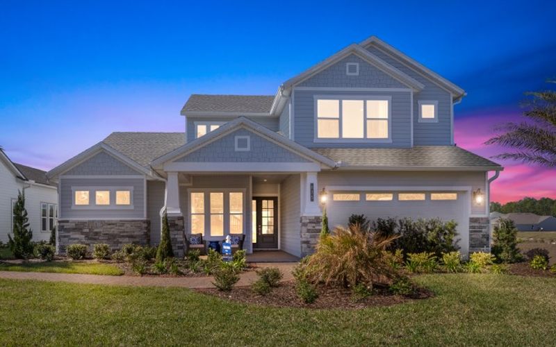 Two-story home at twilight with glowing windows