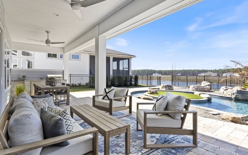 Covered patio overlooking a pool and water